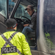 OTTAWA, ON - JANUARY 31: A police officer speaks with a trucker blocking the street on January 31, 2022 in Ottawa, Canada. Thousands turned up over the weekend to rally in support of truckers using their vehicles to block access to Parliament Hill, most of the downtown area Ottawa, and the Alberta border in hopes of pressuring the government to roll back COVID-19 public health regulations.